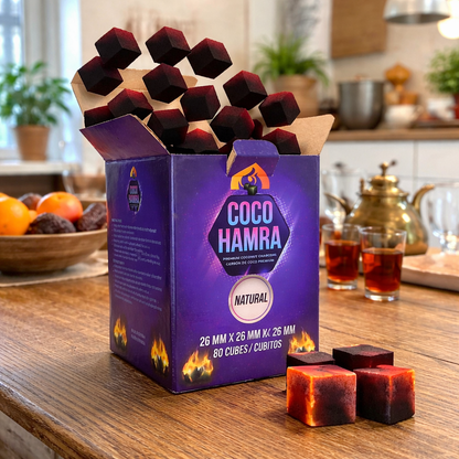 Box of Coco Hamra cubes on a kitchen counter with tea and fruit in the background